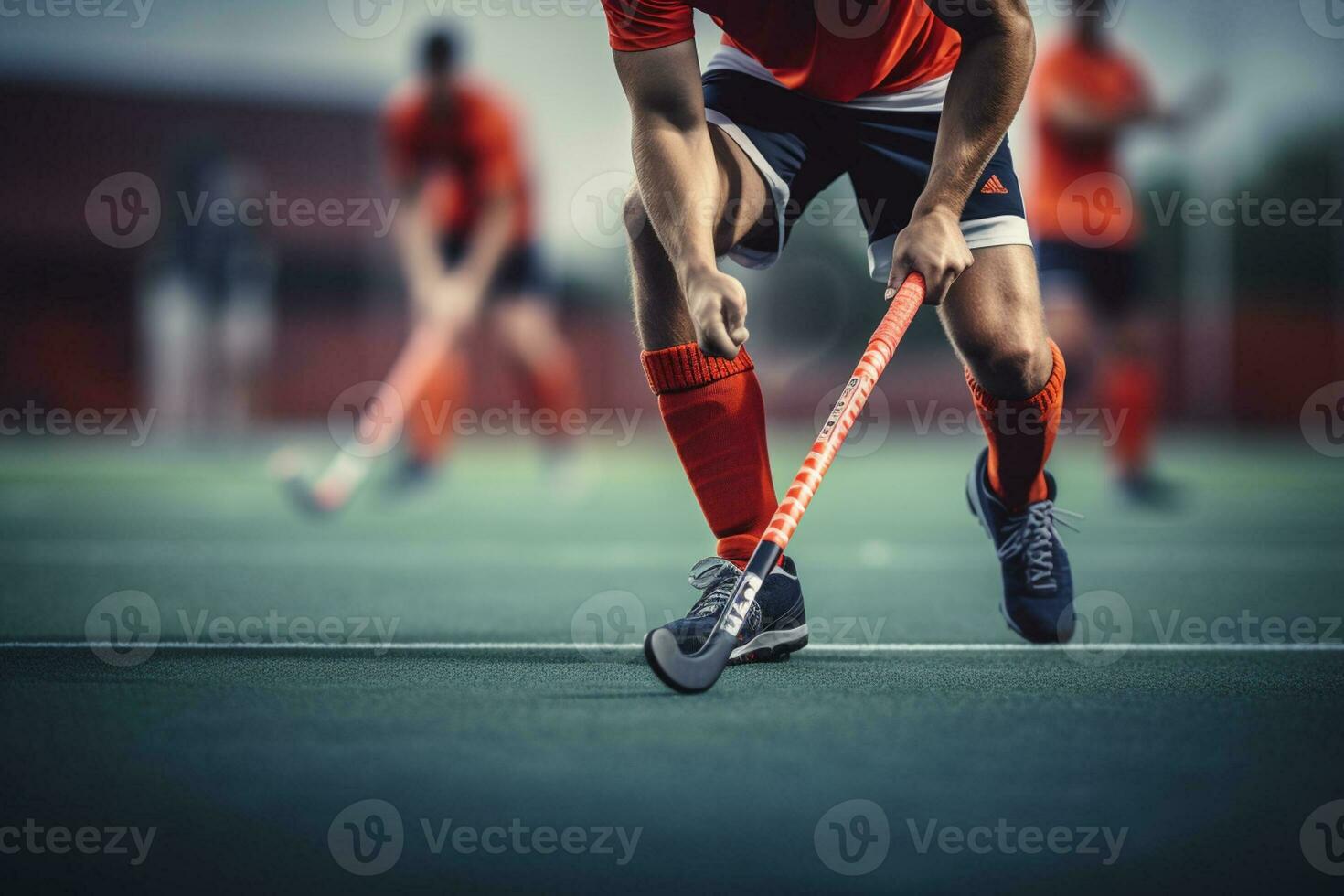 A male hockey player is playing field hockey photo