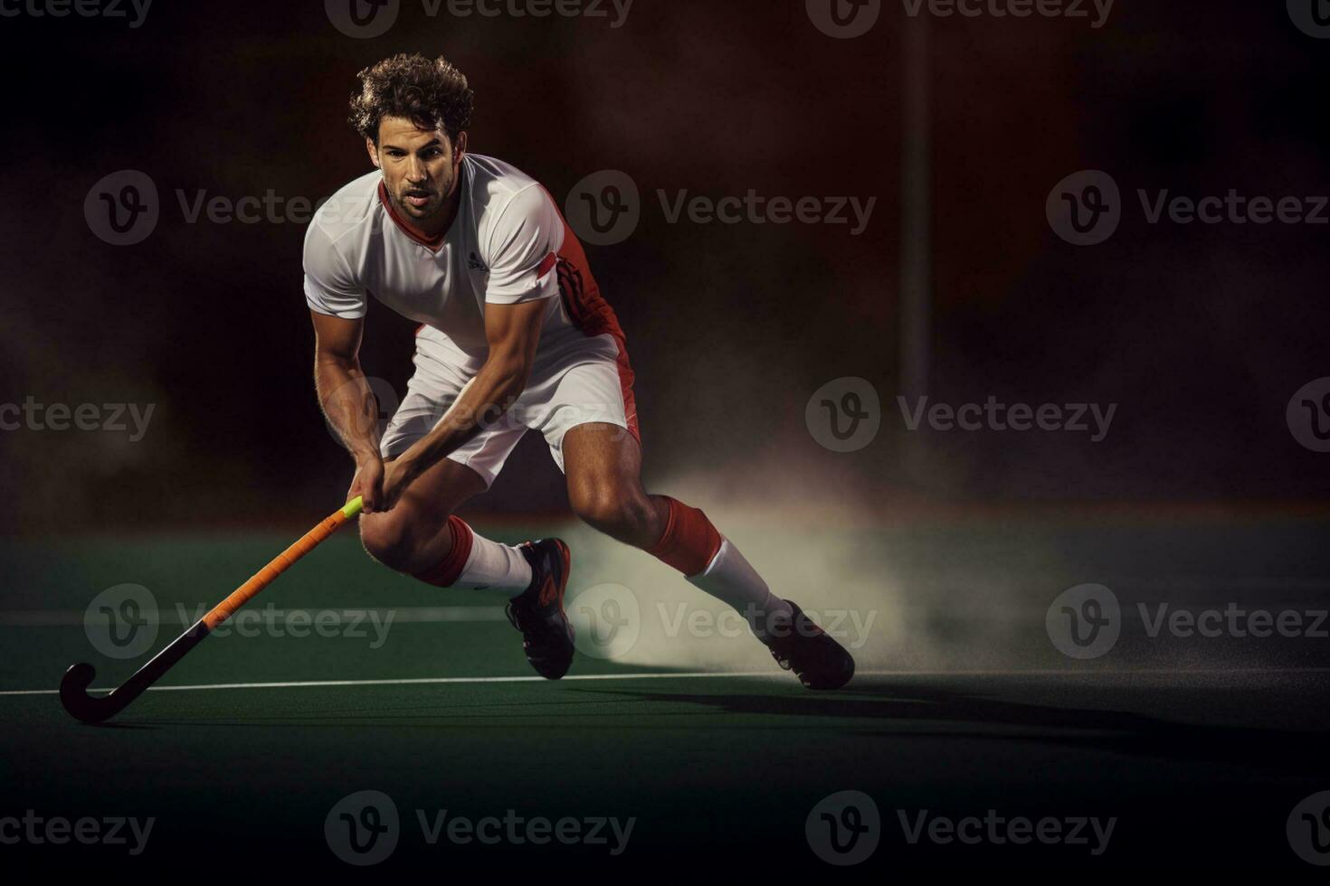 A male hockey player is playing field hockey photo