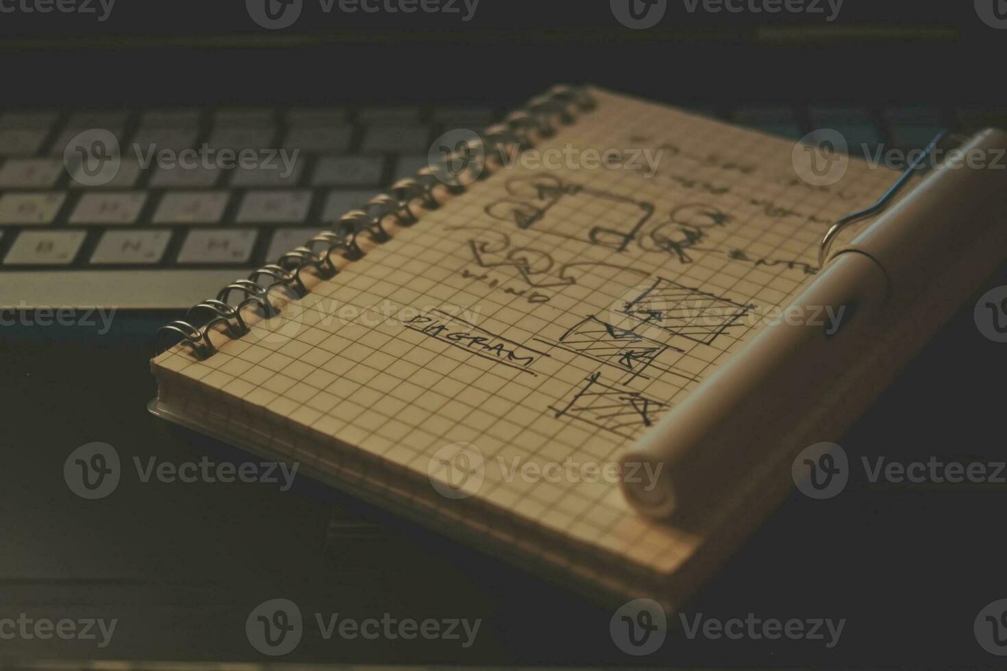 Notebook and pen on the keyboard of a laptop, business concept, drawing architect, architect, architecture, architectural drawings, architecture student, notebook, modern architecture. photo