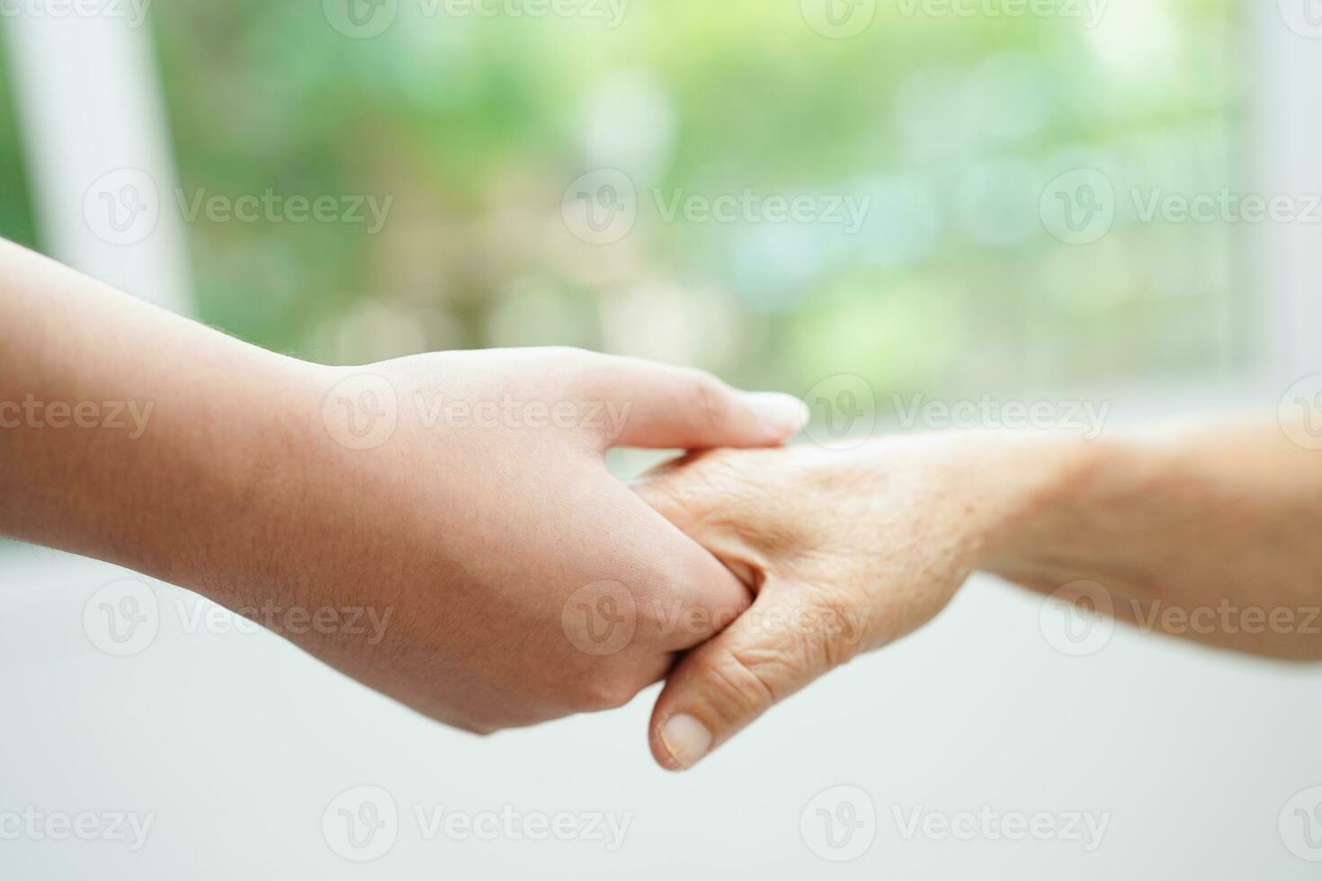 Asian young boy holding old grandmother woman hand together with love and care. photo