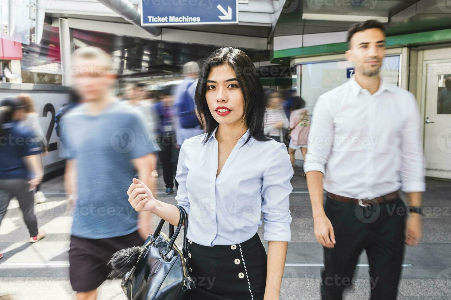 Thailand, Bangkok, portrait of businesswoman amidst moving people in the city photo