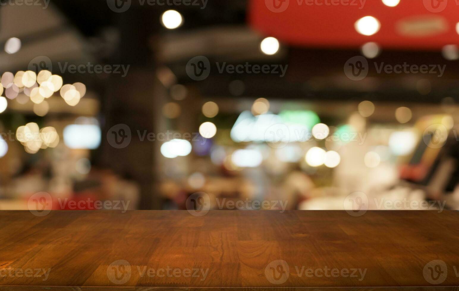 Mock up for space. Empty dark wooden table in front of abstract blurred bokeh background of restaurant . can be used for display or montage your product photo