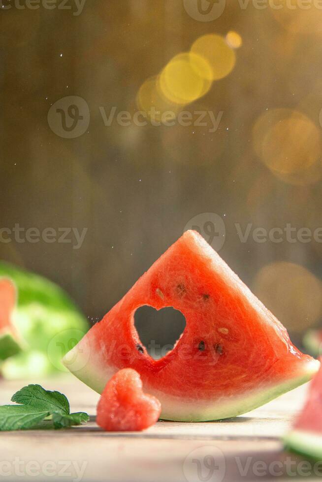 A cut piece of watermelon with a heart-shaped hole. Summer, joy, happiness, delicious food photo