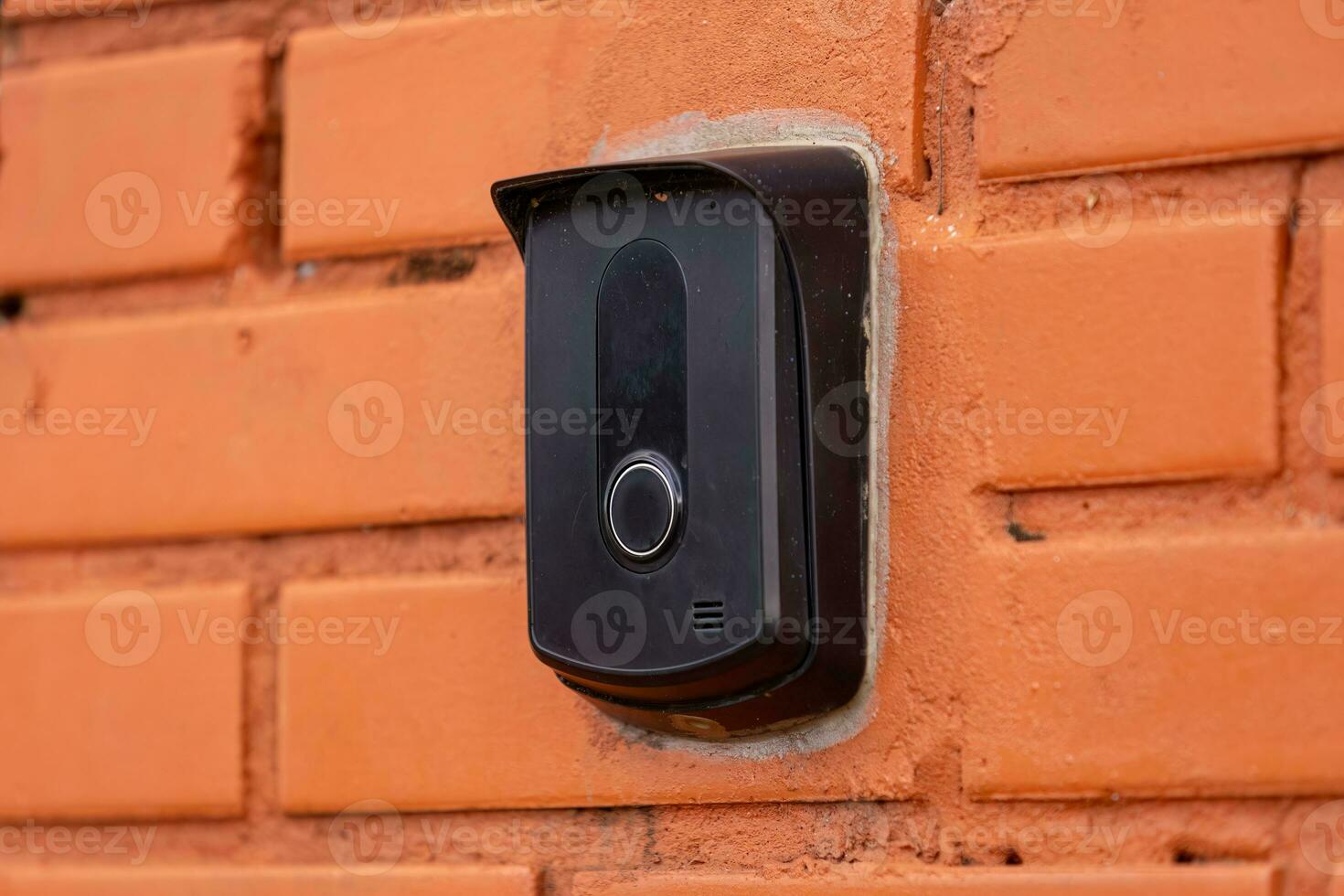 black intercom device on a brick wall photo