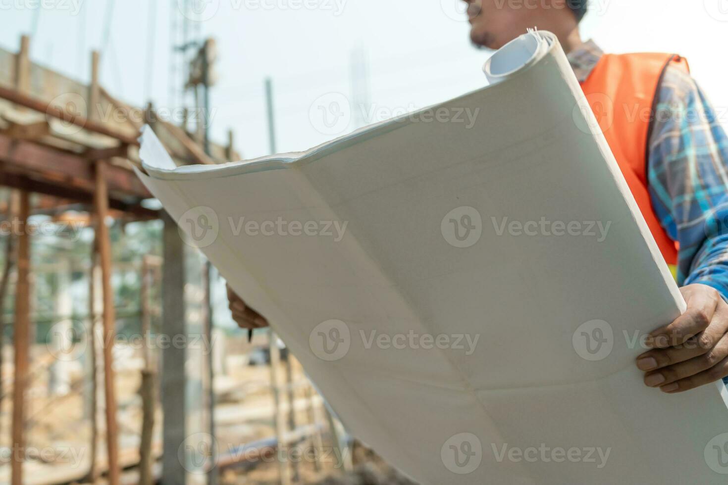inspector or engineer is inspecting construction and quality assurance new house using a blue print. Engineer or architects or contactor work to build the house before handing it over to the homeowner photo