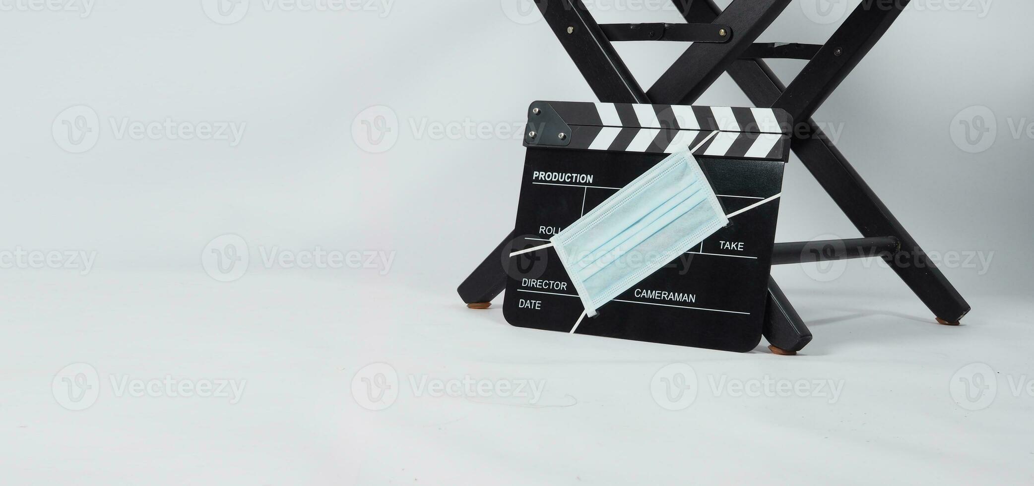 Director chair and black Clapper board or movie slate with face mask. it use in video production and cinema industry on white background. photo