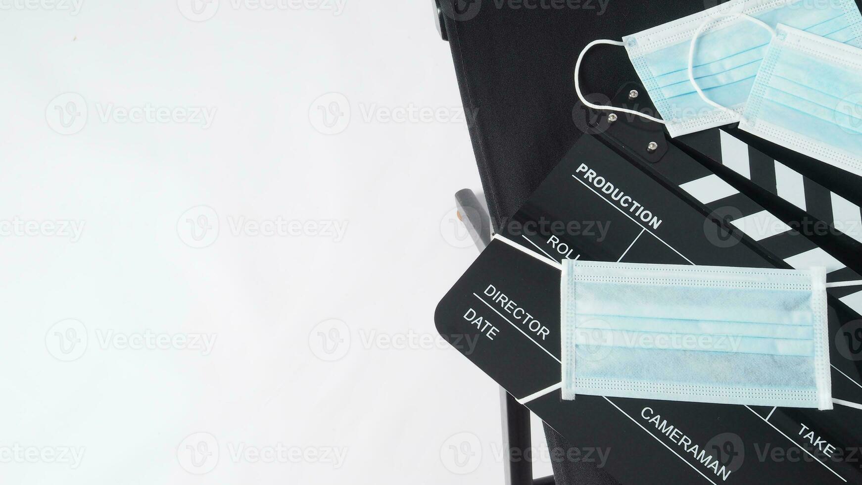 Director chair and black Clapper board or movie slate with face mask. it use in video production and cinema industry on white background. photo