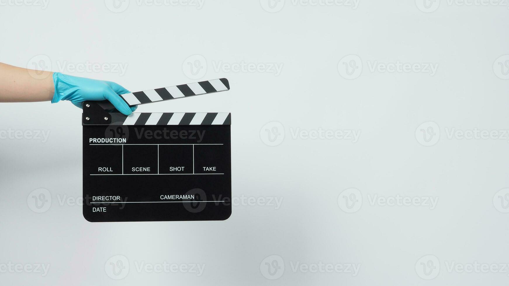 Hand is wear gloves and hold black Clapper board or movie slate. it use in video production and cinema industry on white background. photo