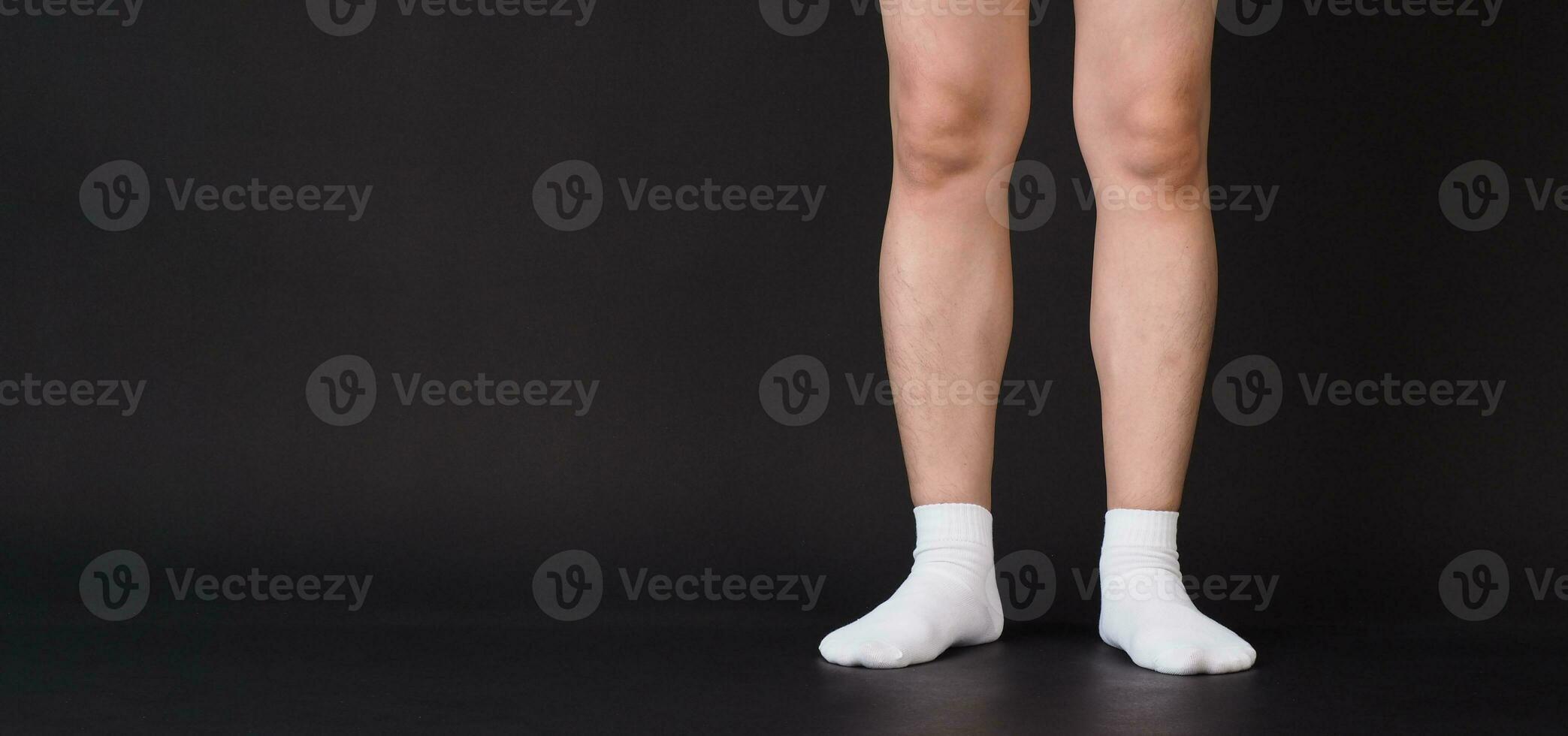 Asian Male legs wear white sock is isolated on black background photo