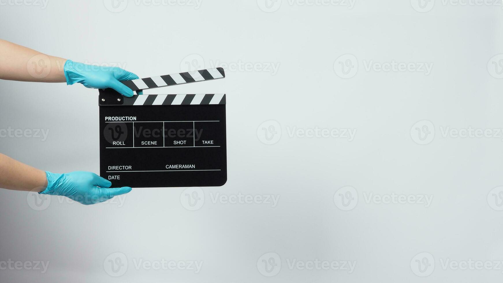 Hand is wear gloves and hold black Clapper board or movie slate. it use in video production and cinema industry on white background. photo
