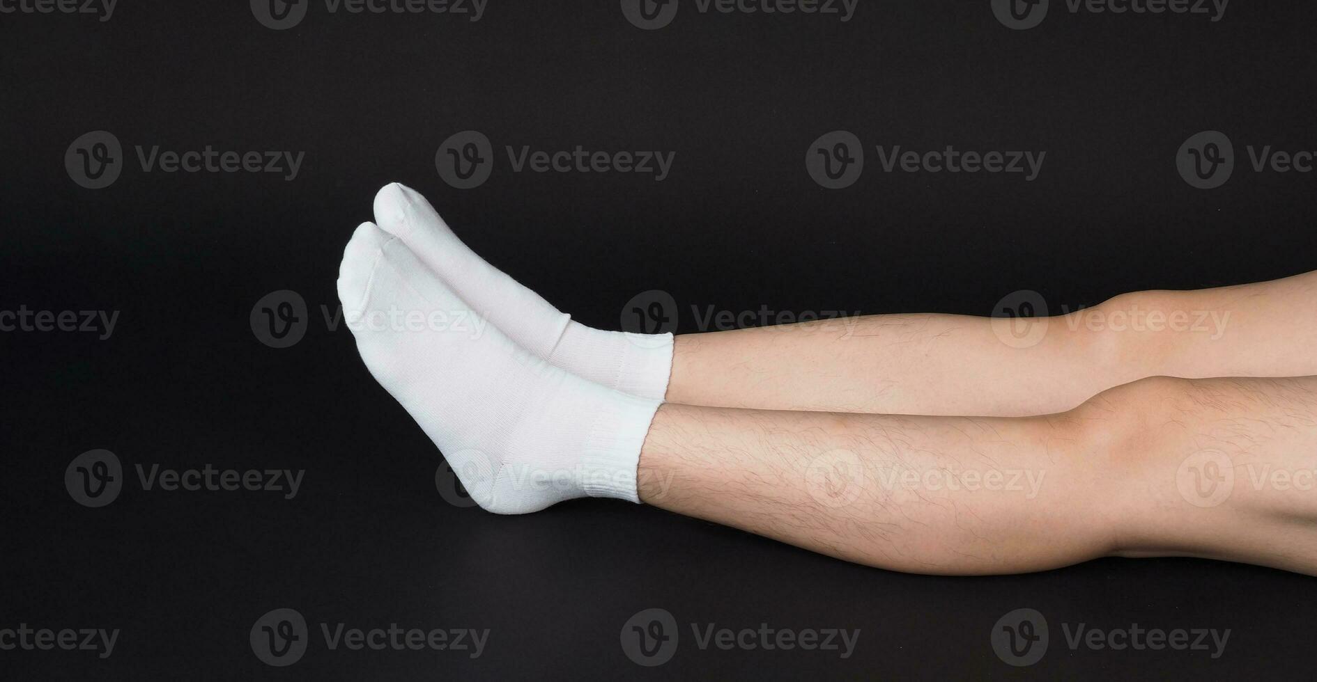 Asian Male legs wear white sock is isolated on black background photo