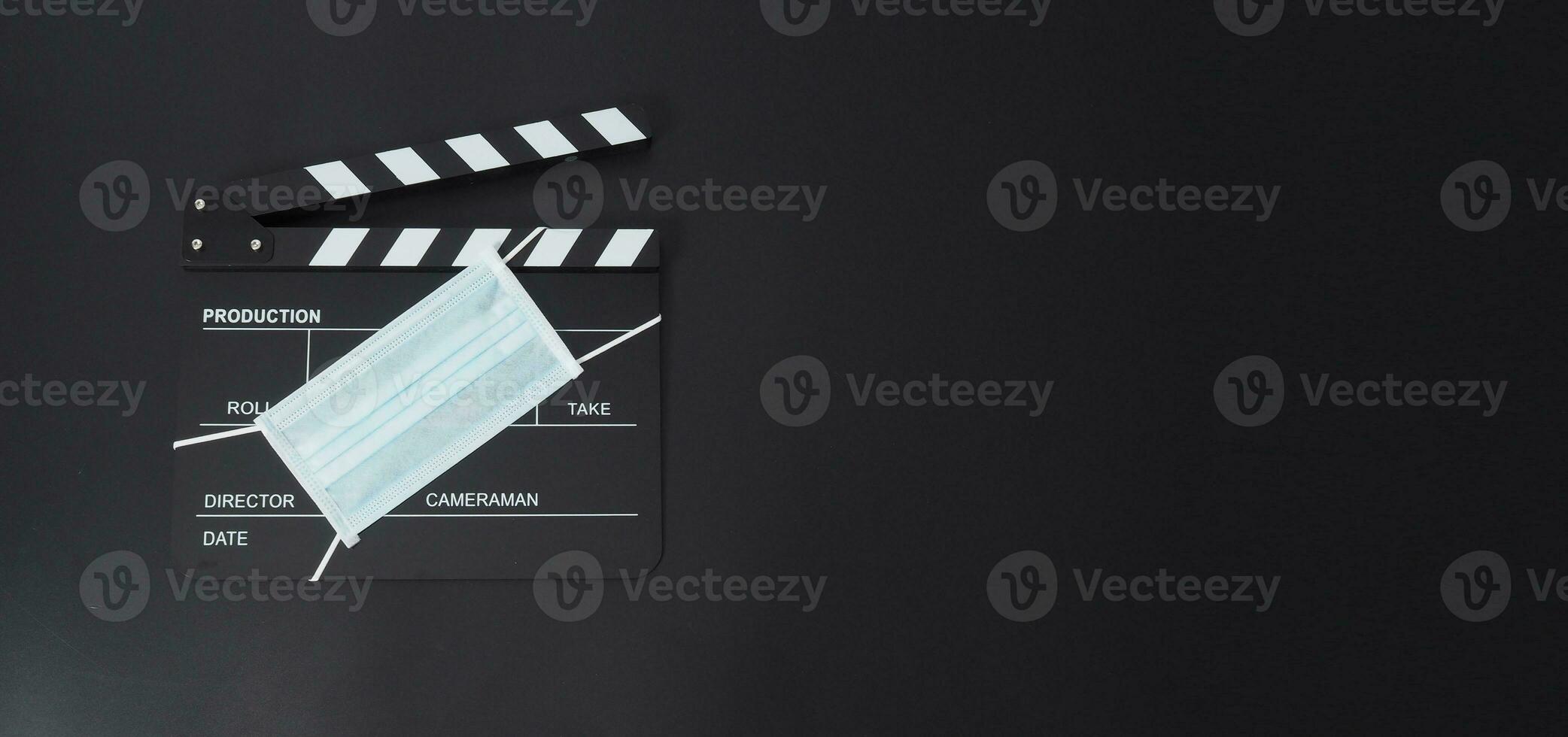 Clapper board or movie slate with face mask. it use in video production and cinema industry on black background. photo