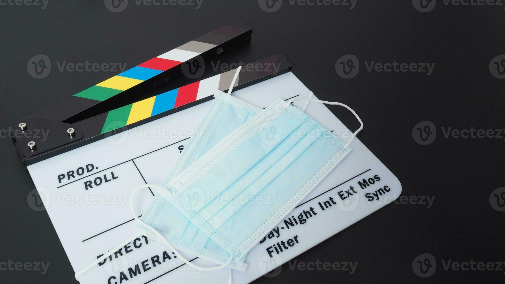 Clapper board or movie slate with face mask. it use in video production and cinema industry on black background. photo
