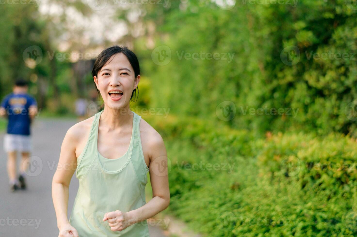 Fit Asian young woman jogging in park smiling happy running and enjoying a healthy outdoor lifestyle. Female jogger. Fitness runner girl in public park. healthy lifestyle and wellness being concept photo