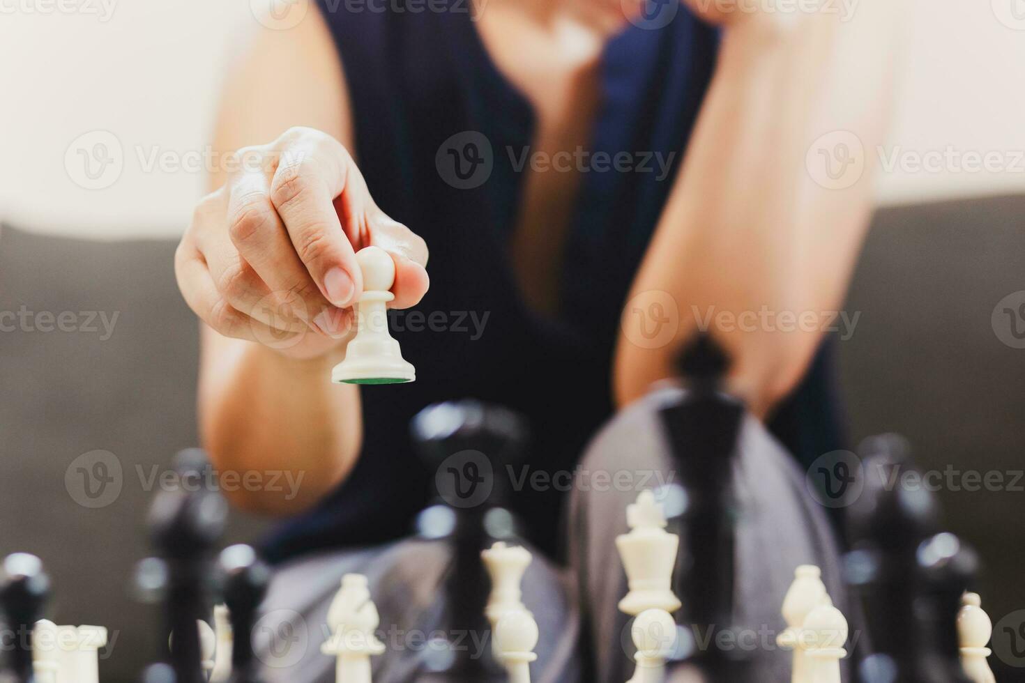 Woman playing chess board game at home. photo