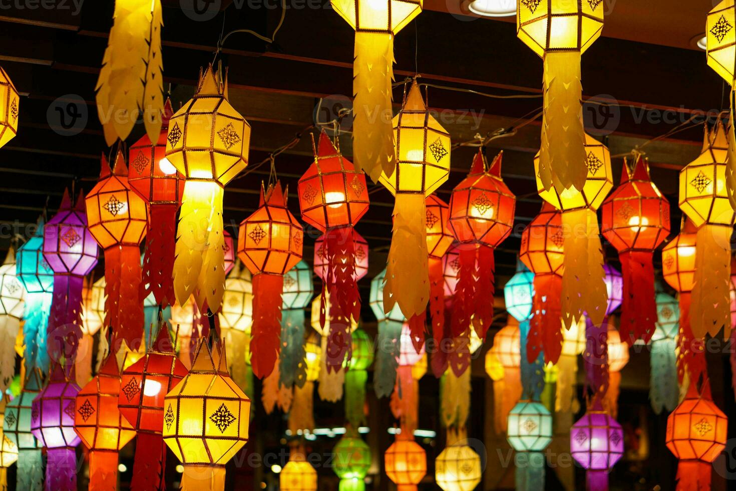 Closeup Colorful perspective view of Thai Lanna style lanterns to hanging on the ceiling and turn on light at night. photo