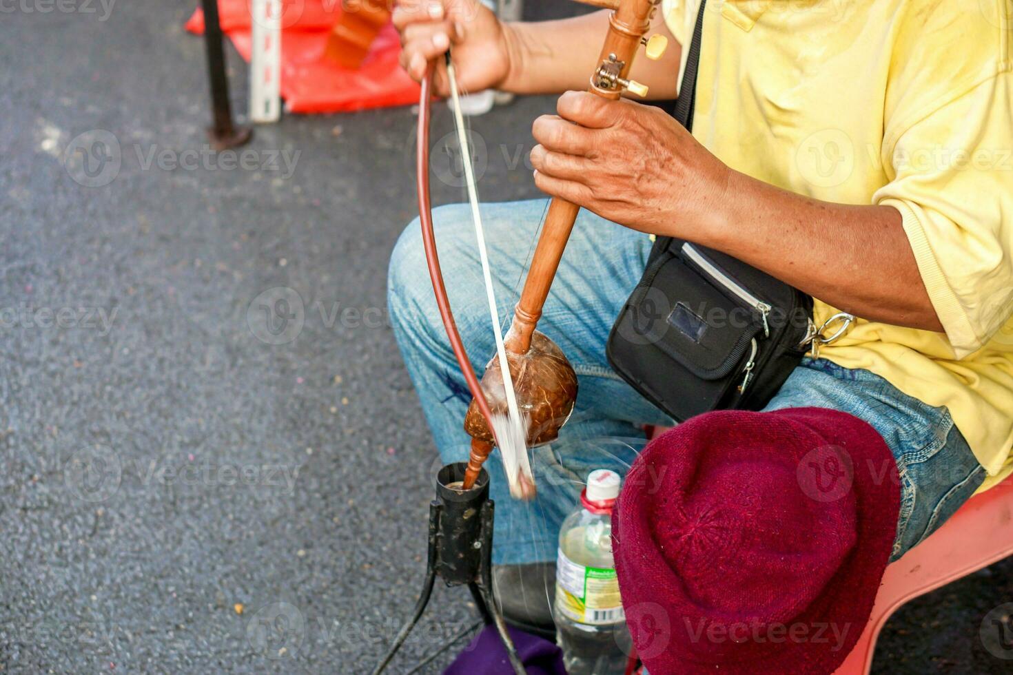 Closeup hands of Thai street musician playing Thai fiddle at Chiang mai walking street. The Thai fiddle is used in stringed instruments as the conductor and is the basis for the reference melody. photo