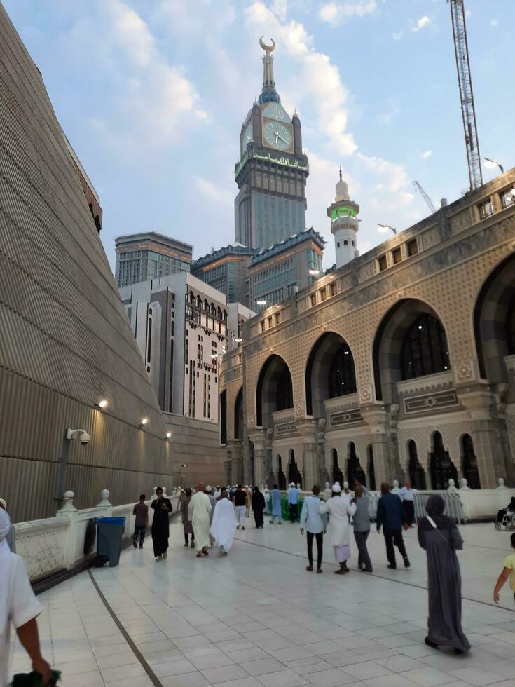 Mecca, Saudi Arabia, Sep 2023 - A beautiful view of the Makkah Royal Clock Tower at sunset. Pilgrims from all over the world are busy preparing for Maghrib prayers. photo