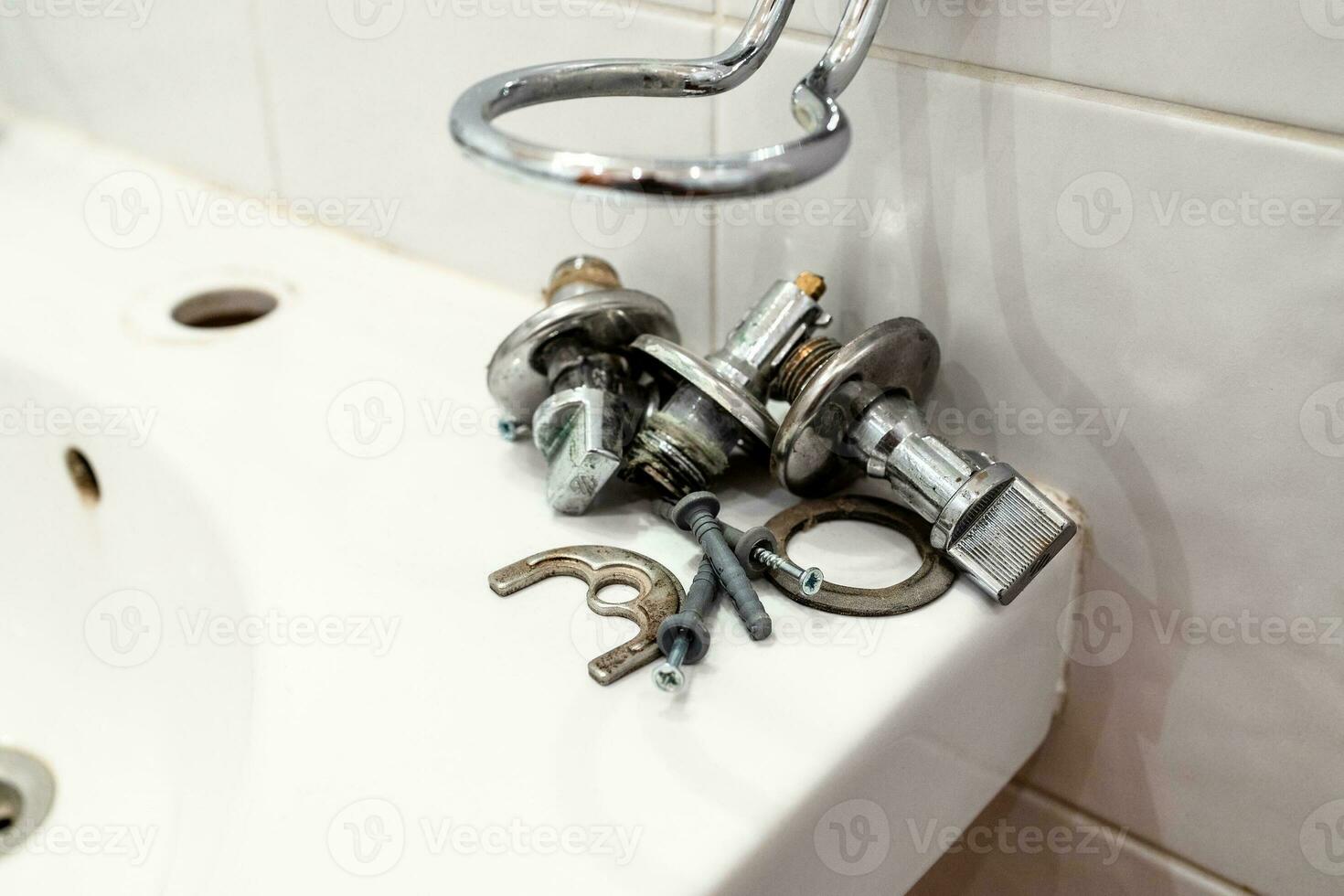 old ball valves and fixtures lie on edge of sink photo