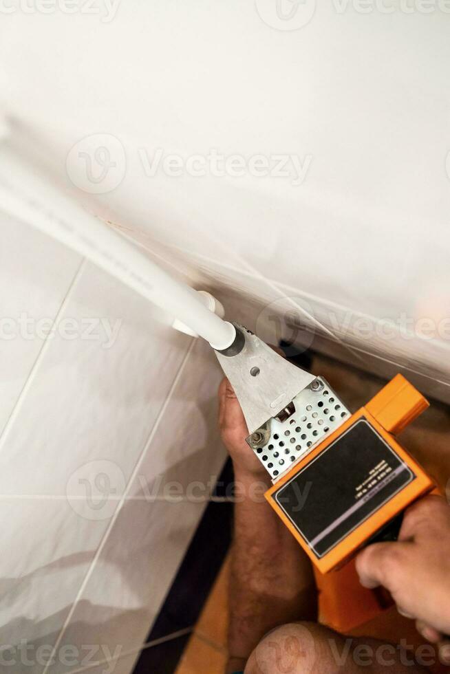 plumber fits polypropylene pipe with solder photo