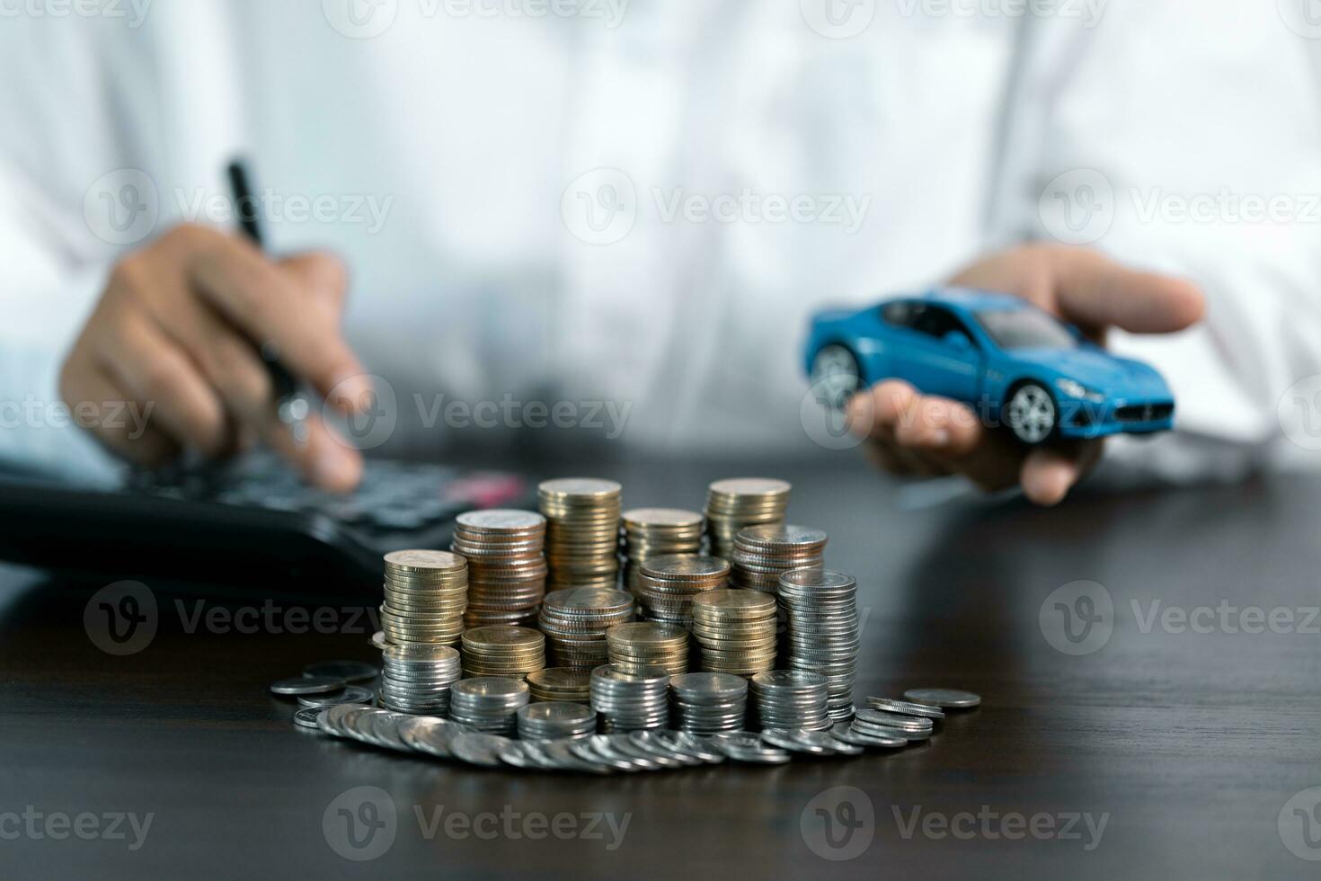 Blue Toy Car In Front Of Businessman Calculating Loan. Saving money for car concept, trade car for cash concept, finance concept. photo