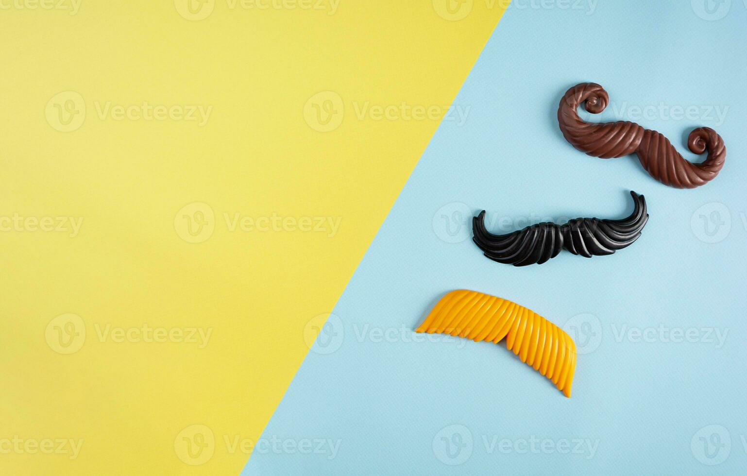 Curly mustaches on colorful background. Fake mustache. Top view photo