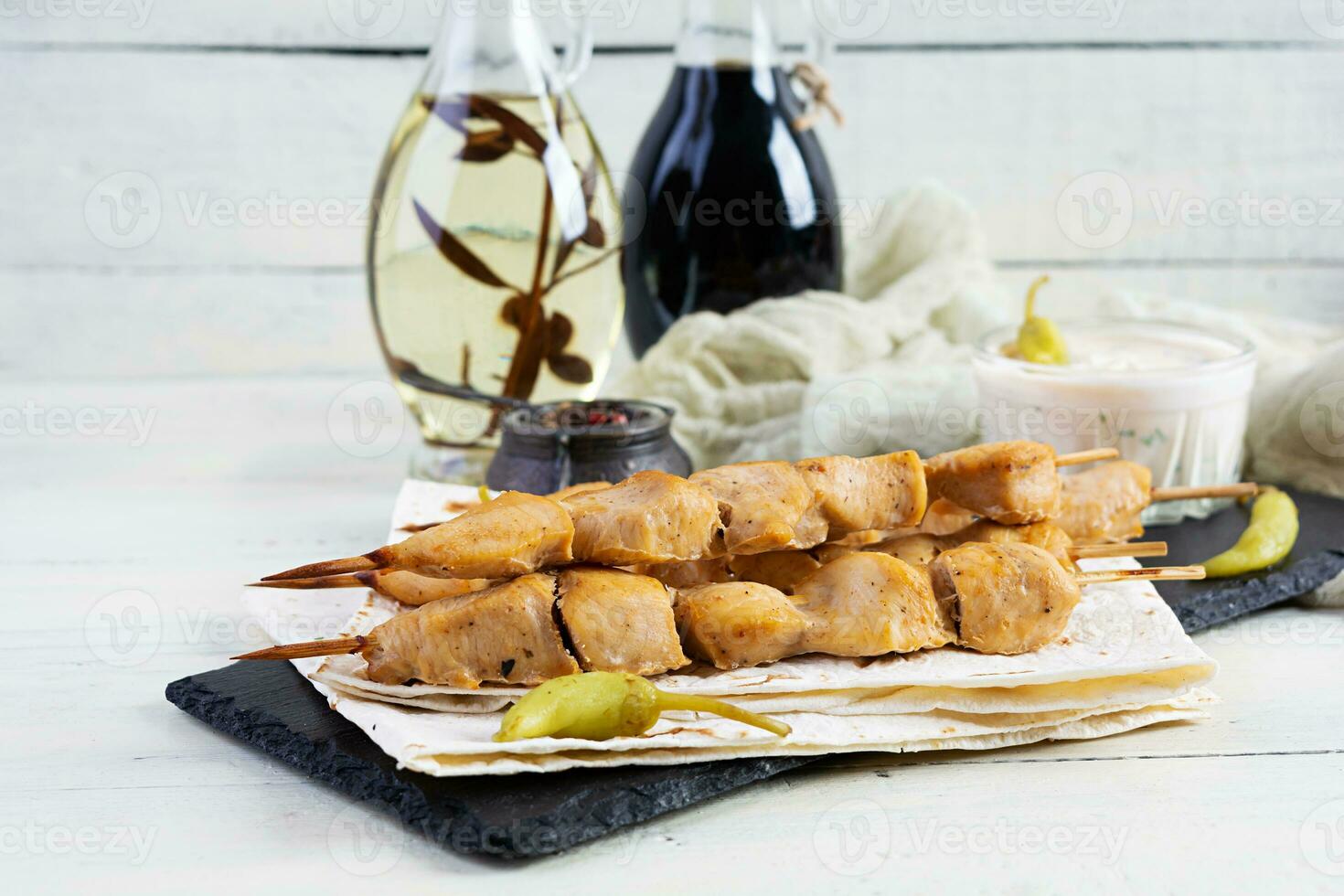 Chicken kebab with sour cream sauce. Chicken skewers on wooden background photo