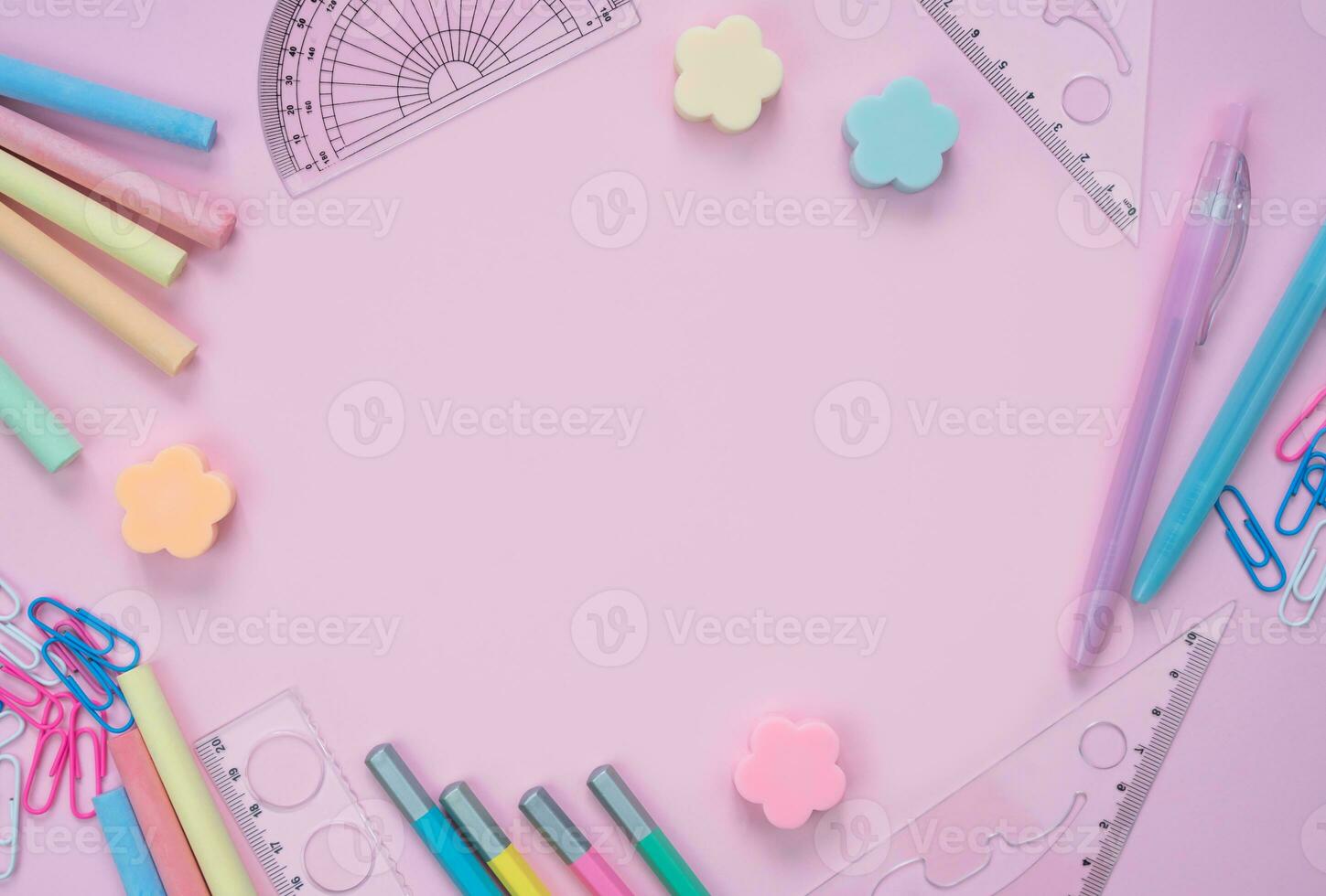 School stationery lie in the shape of a frame on pink background. Back to school. Flatlay composition. Top view. Copy space. photo