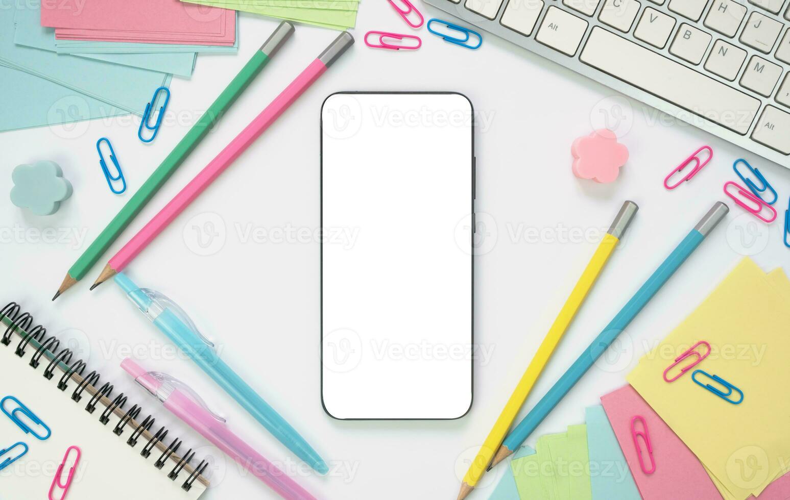 Smartphone with white screen and school supplies around on the table. Online learning concept. Mockup. Flatlay. Top view. Copy space. photo