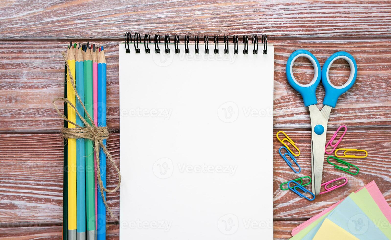 Back to school. Blank notepad and school stationery on a wooden background. Flatlay composition. Mockup. Top view. Copy space. photo