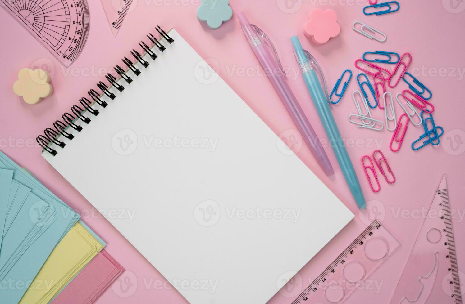 Back to school. Mockup. School composition with blank notepad and stationery on a pink background. Flatlay. Top view. Copy space. photo