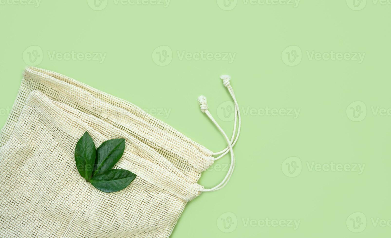 Reusable shopping bags on the green background. Zero waste concept. Top view. Copy space. photo