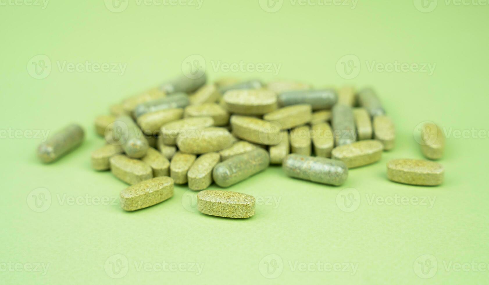 Natural vitamins and supplements on a green background. Close-up. Selective focus. photo