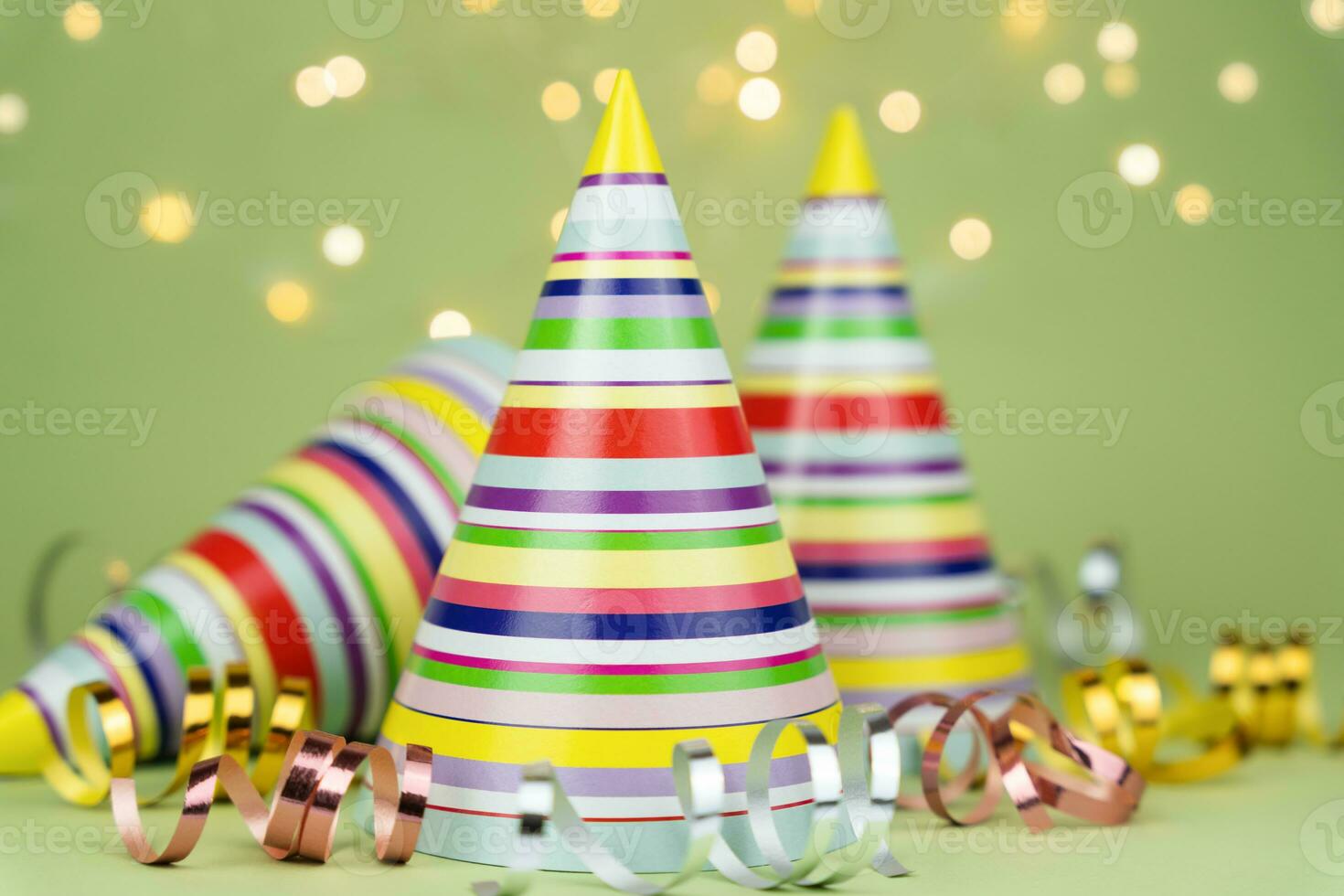 Colored party hats for holiday party on green background. Copy space. Close-up. photo