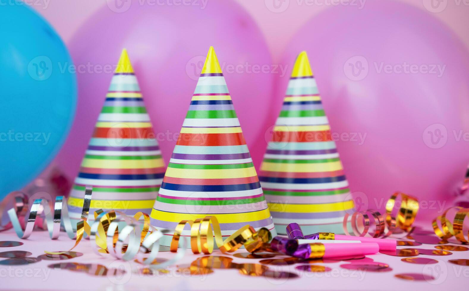 Colored party hats, balloons, confetti for Birthday party on pink background. Close-up. photo