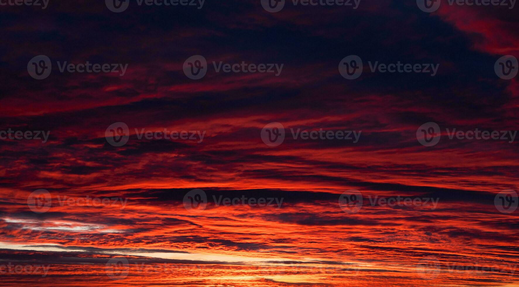 The dark red-orange sky is out of focus. Dramatic sky with dark clouds. Sunset. Banner. Noise. photo