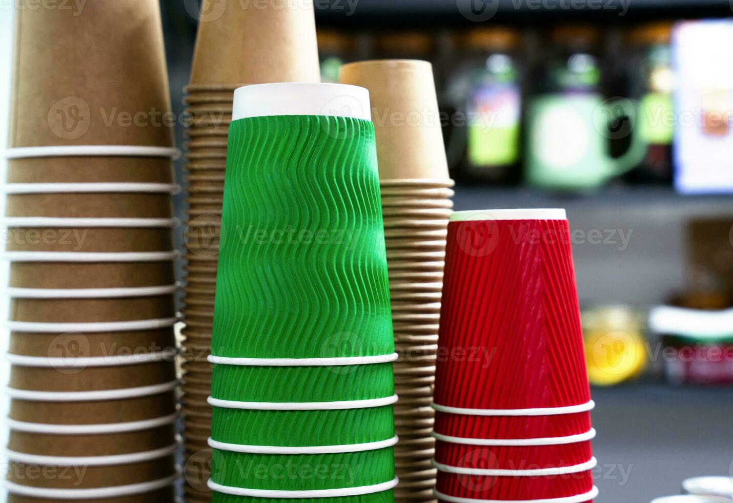 A stack of colorful disposable paper cups in a cafe. Paper cups from kraft paper for various drinks. Close-up. Selective focus. photo