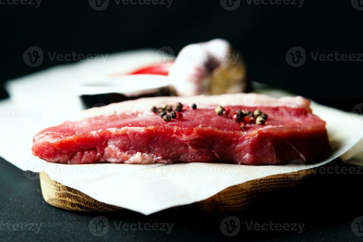 Raw organic beef meat with rosemary, seasonings, salt and red pepper  on black background photo