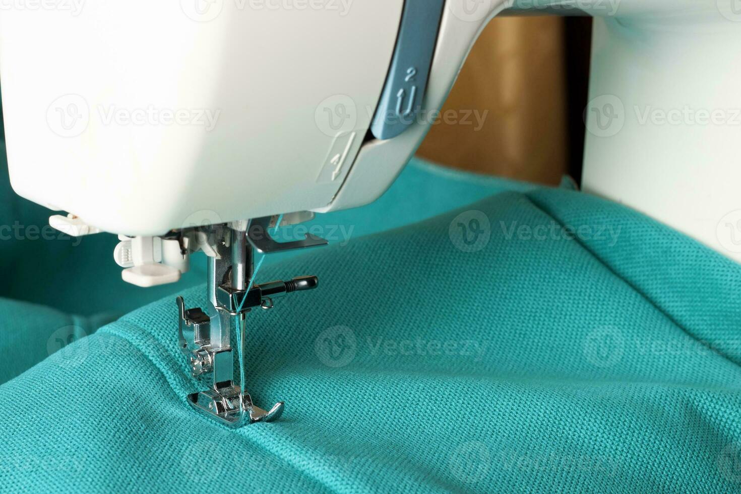 Modern sewing machine and turquoise fabric photo