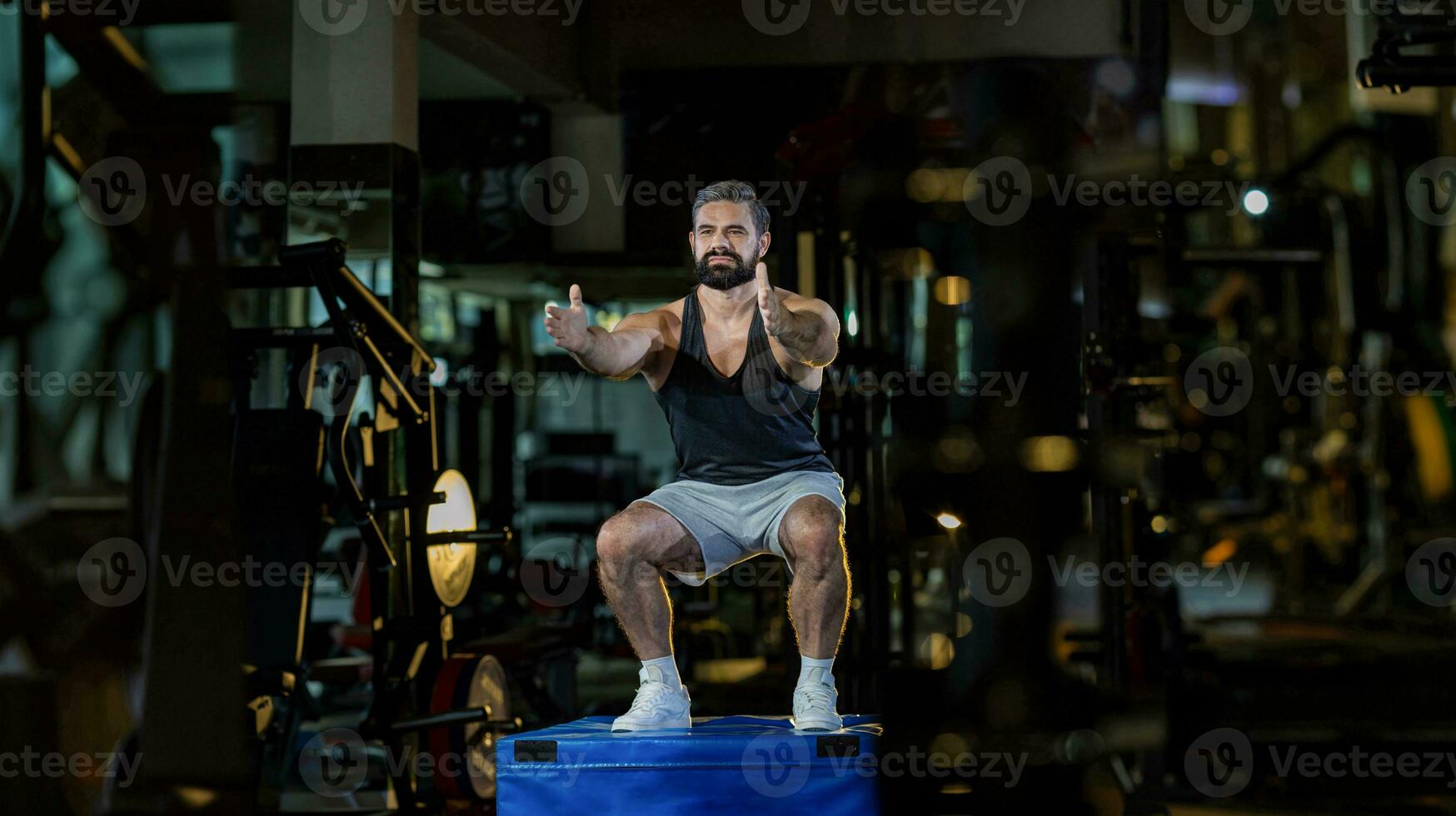 Caucasian man with strong and muscular firm shape is training on leg day by doing advance jump squat for thigh and calf muscle in gym for healthy and strong lower body weight strength photo