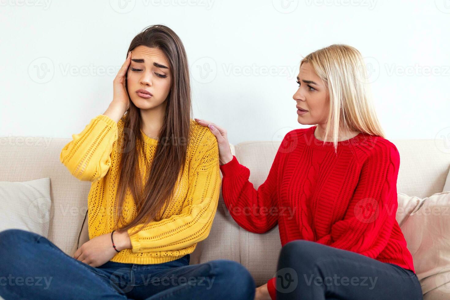 Sad women and supporting friends trying to solve a problem. Two sad diverse women talking at home. Female friends supporting each other. Problems, friendship and care concept photo