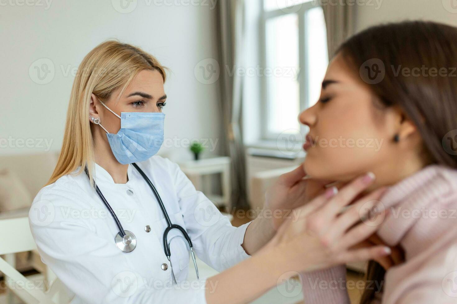 Young woman sitting while the nurse examining her throat. physician checking patient thyroid gland, health examination in hospital photo
