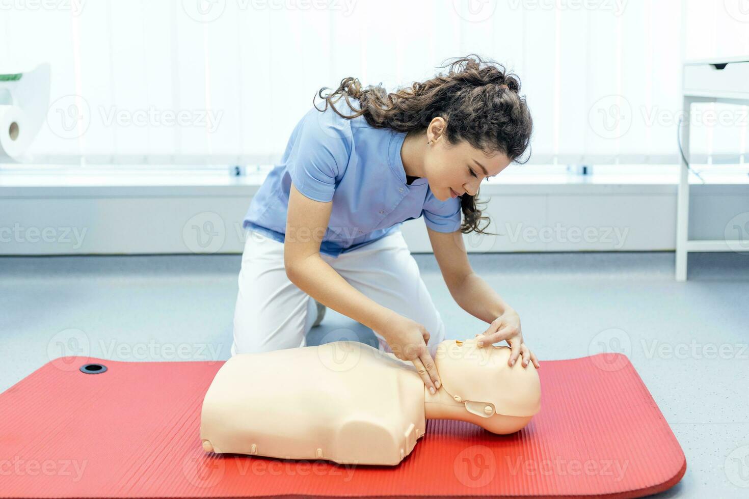 woman practicing cpr technique on dummy during first aid training. First Aid Training - Cardiopulmonary resuscitation. First aid course on cpr dummy. photo