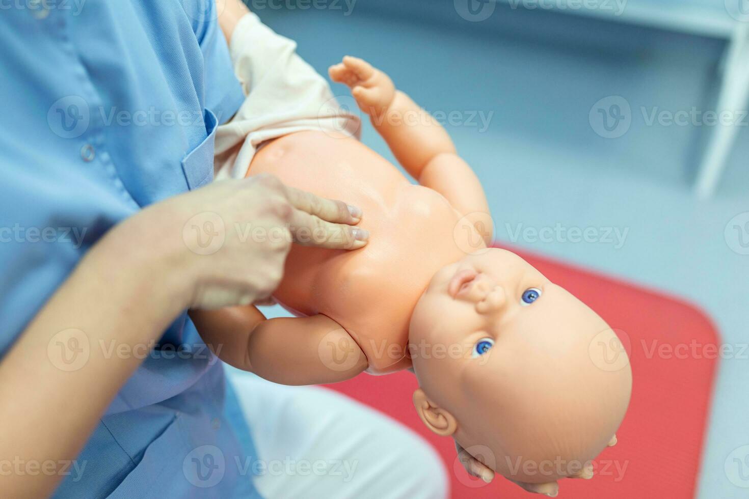 Woman performing CPR on baby training doll with one hand compression. First Aid Training - Cardiopulmonary resuscitation. First aid course on cpr dummy. photo