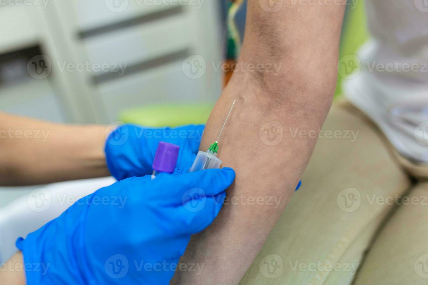 Medical technologist doing a blood draw services for patient. lab assistant with sterile rubber gloves taking blood sample from patient. photo