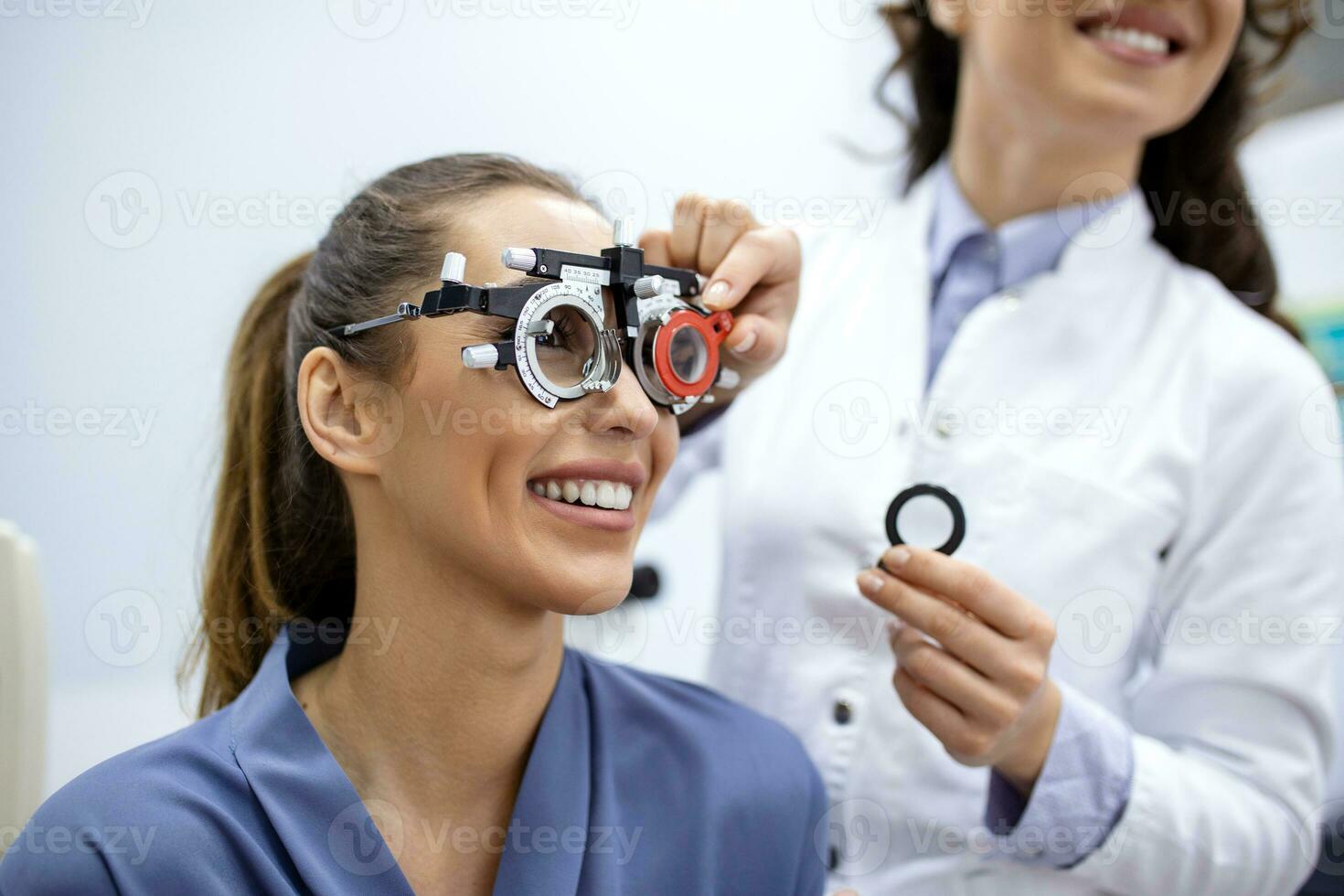 oftalmólogo que examina a la mujer con marco de prueba de optometrista. paciente femenina para comprobar la visión en la clínica oftalmológica foto