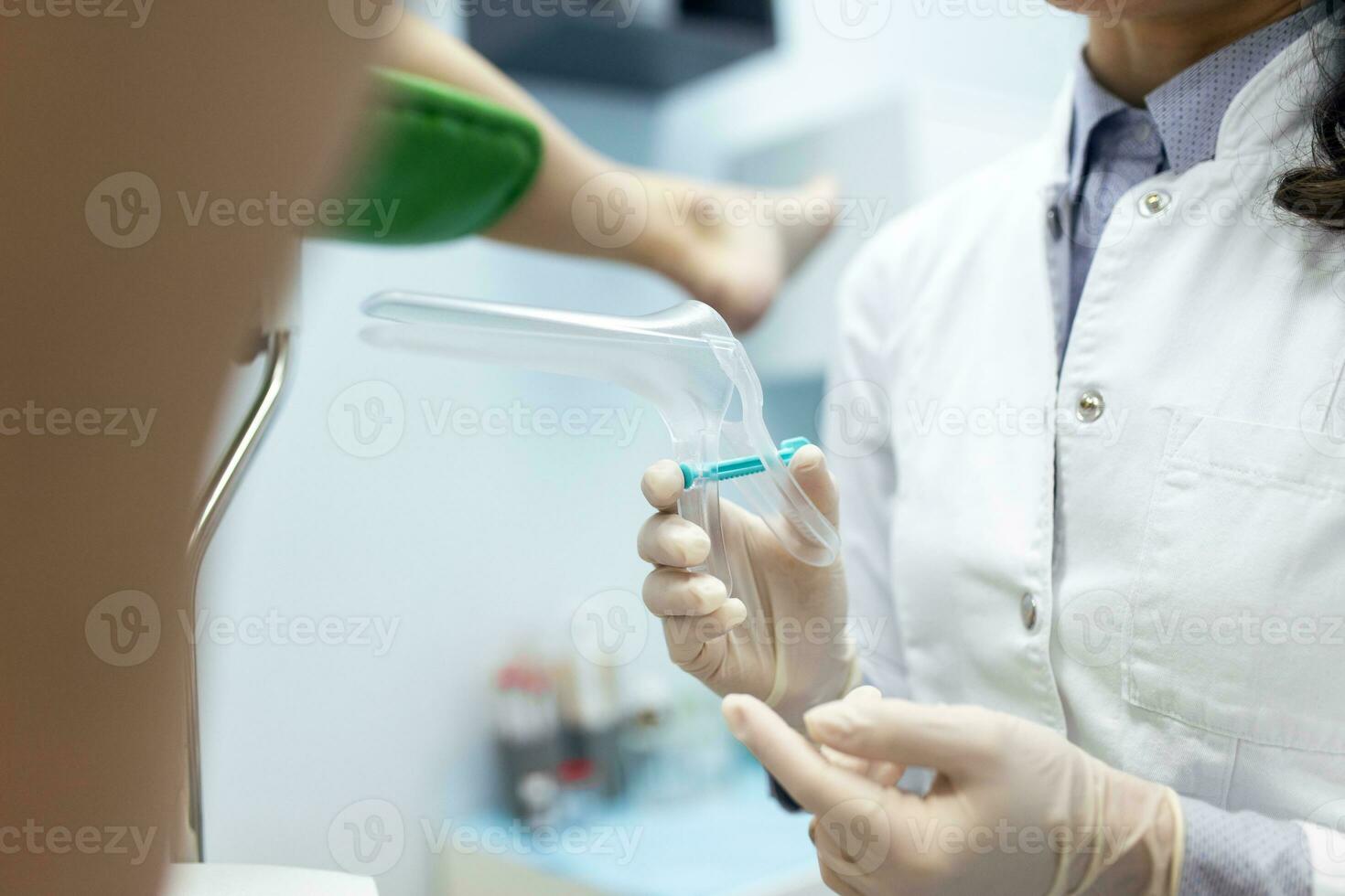 Treatment of cervical disease. Female gynecologist woman patient in gynecological chair during check up with gynecological speculum. Gynecologist examines a woman. Diagnostic, medical service. photo