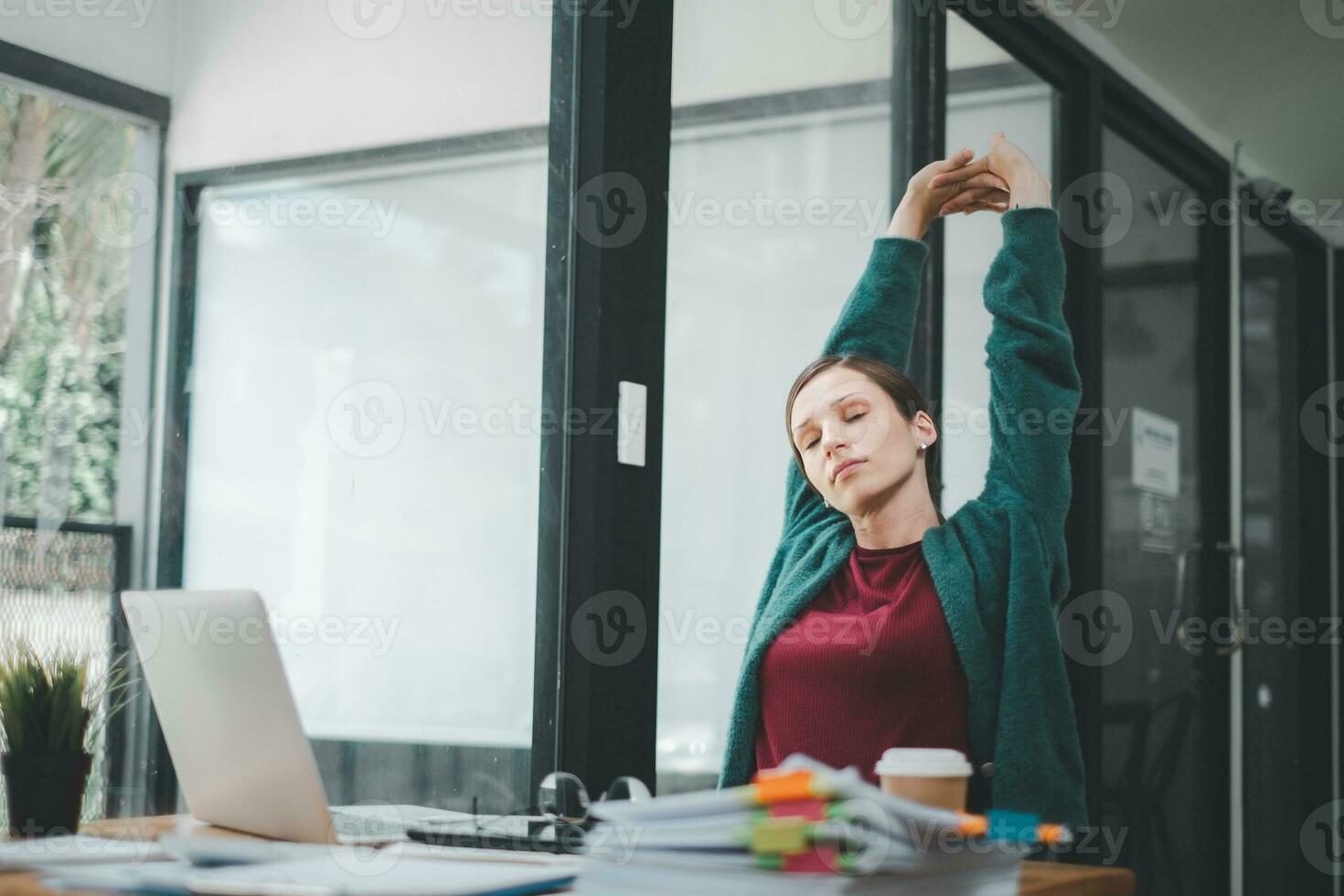 Business woman relaxing with hands behind her head and sitting on an office chair photo