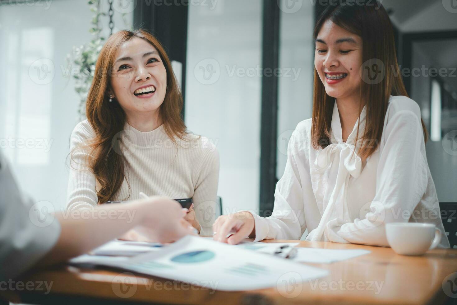 sonriente diverso empleados colegas tener divertido risa cooperar idea genial en computadora a oficina equipo reunión. contento multiétnico gente de negocios trabajo juntos en ordenador portátil discutir negocio ideas en grupo. foto