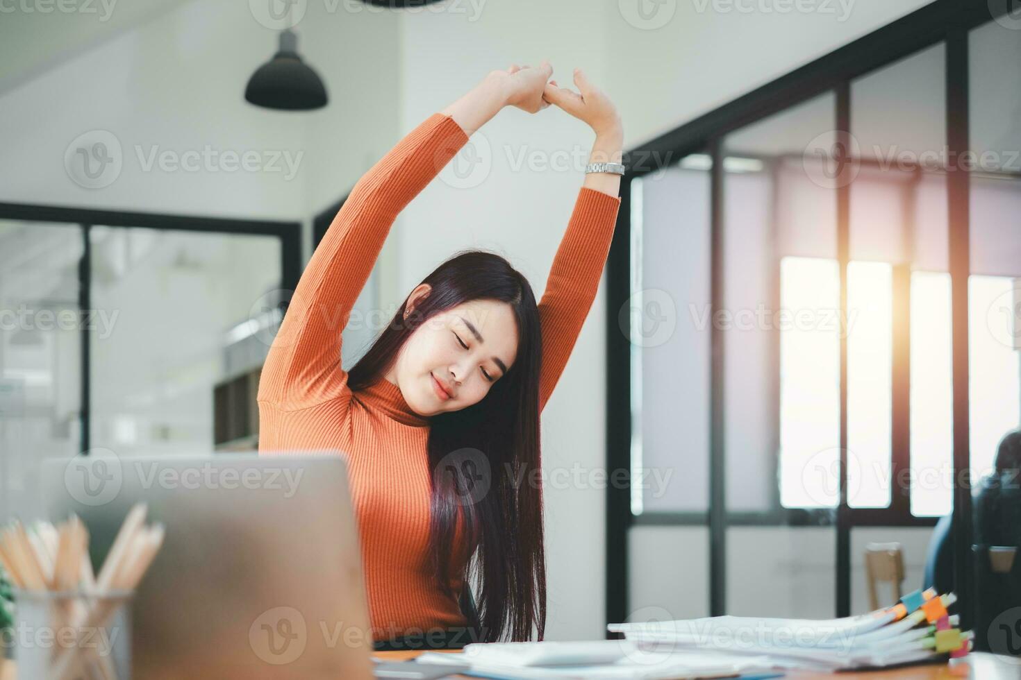 Business woman relaxing with hands behind her head and sitting on an office chair photo